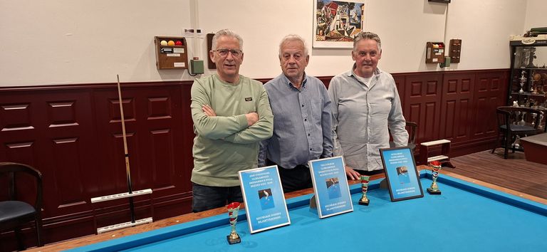 Drie prijswinnaars met hun oorkonde bij het biljart