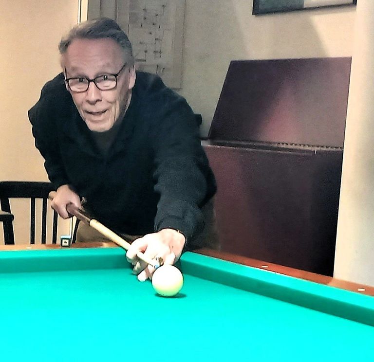 Speler buigt over het biljart en zet de stoot in